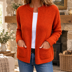 Kerry Zip-Up Knit Cardigan in Orange, shown in a warm Irish cottage interior